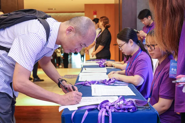 A guest checking in with the conference welcome team