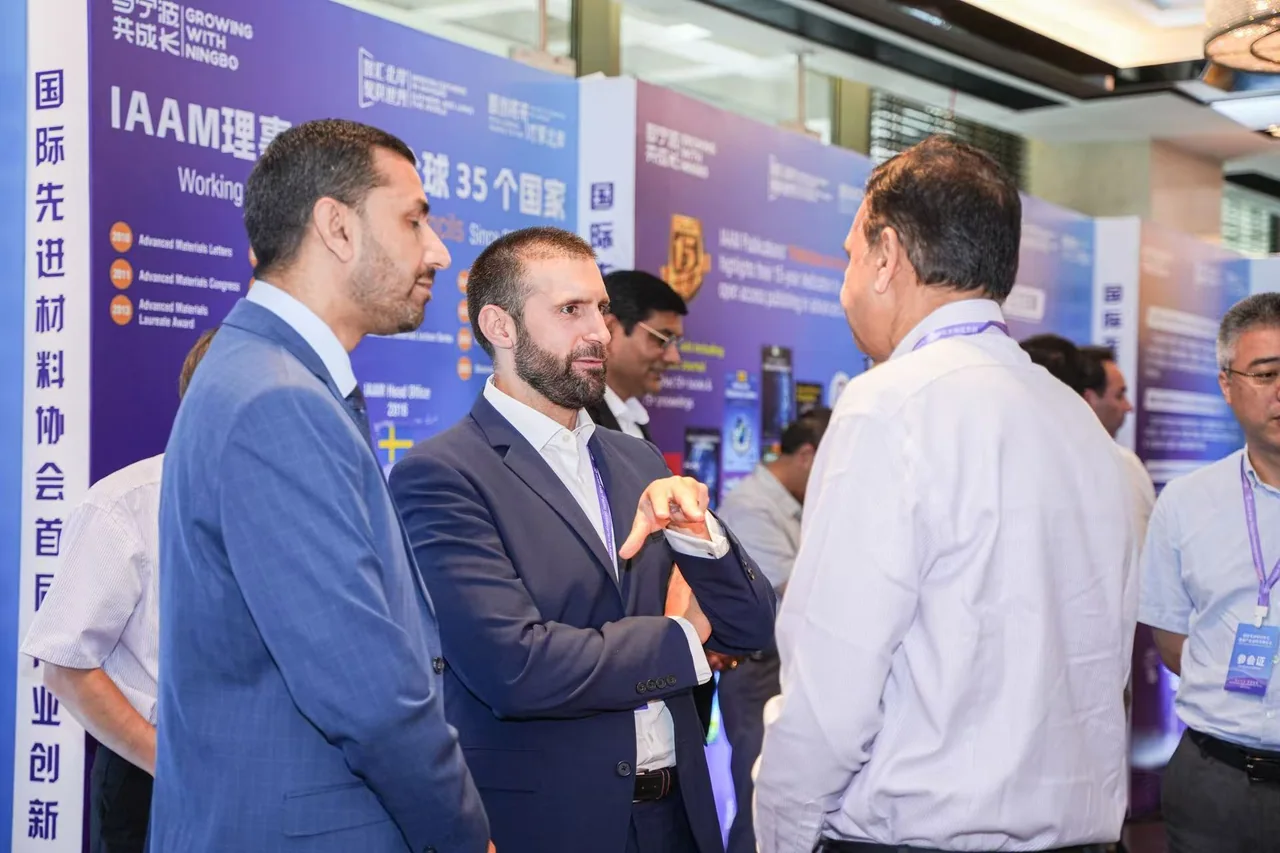 Participants exchanging ideas beside conference exhibition displays