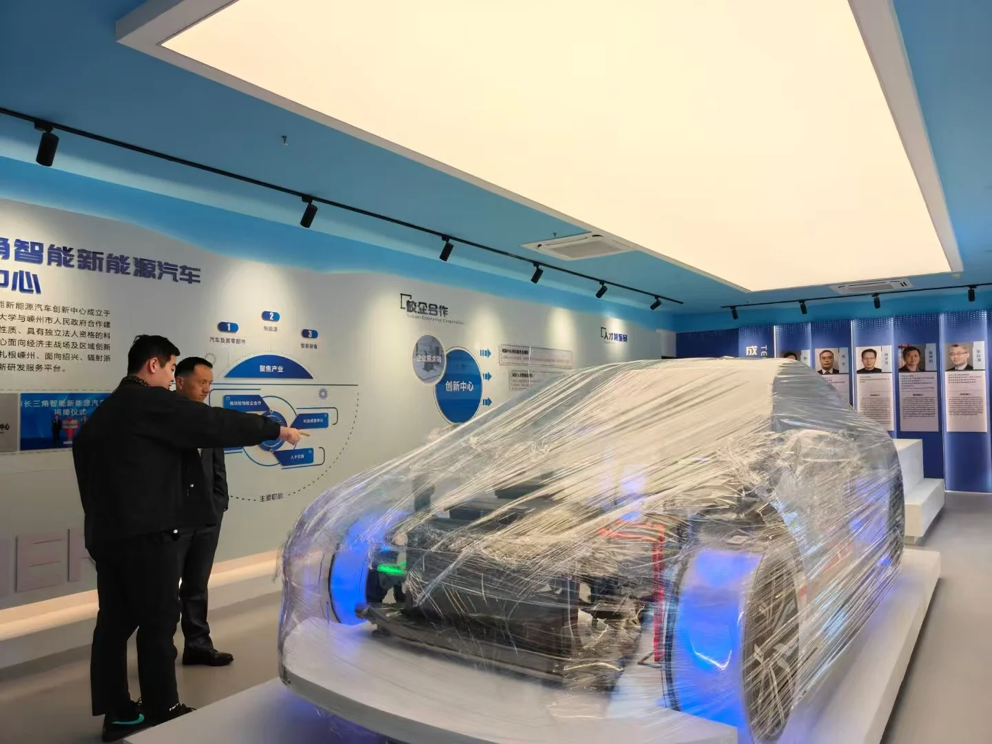Visitors examining an electric vehicle display in a technology showroom